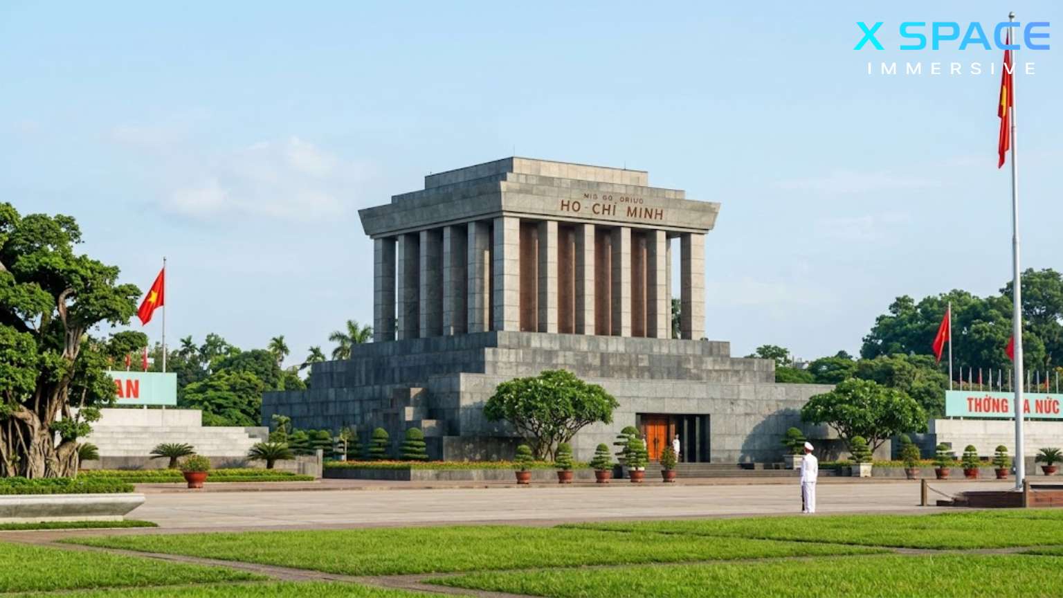 A solemn view of the powerful grey granite Ho Chi Minh Mausoleum and the green grass of Ba Dinh Square under a blue sky in Hanoi