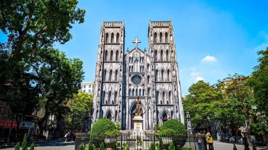 Mặt tiền Nhà thờ Lớn Hà Nội phong cách Tân Gothic dưới bầu trời xanh, hai tháp chuông và tượng Đức Mẹ ở cổng