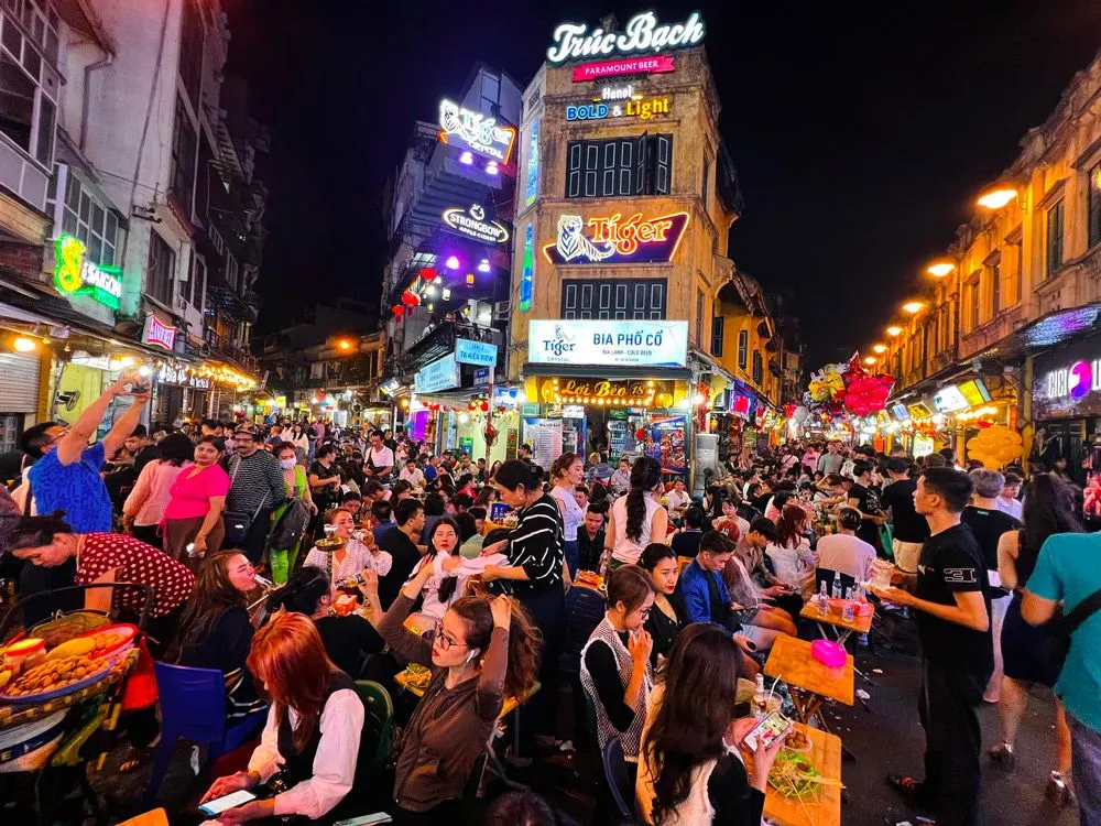Phố Tạ Hiện về đêm đông kín khách ngồi bia vỉa hè dưới biển hiệu đèn neon ở phố cổ Hà Nội