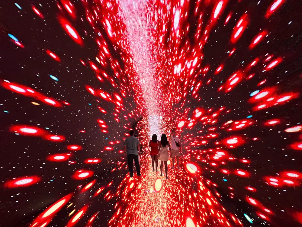Khách đi giữa hầm LED với những dải sáng đỏ tại X Space Immersive
